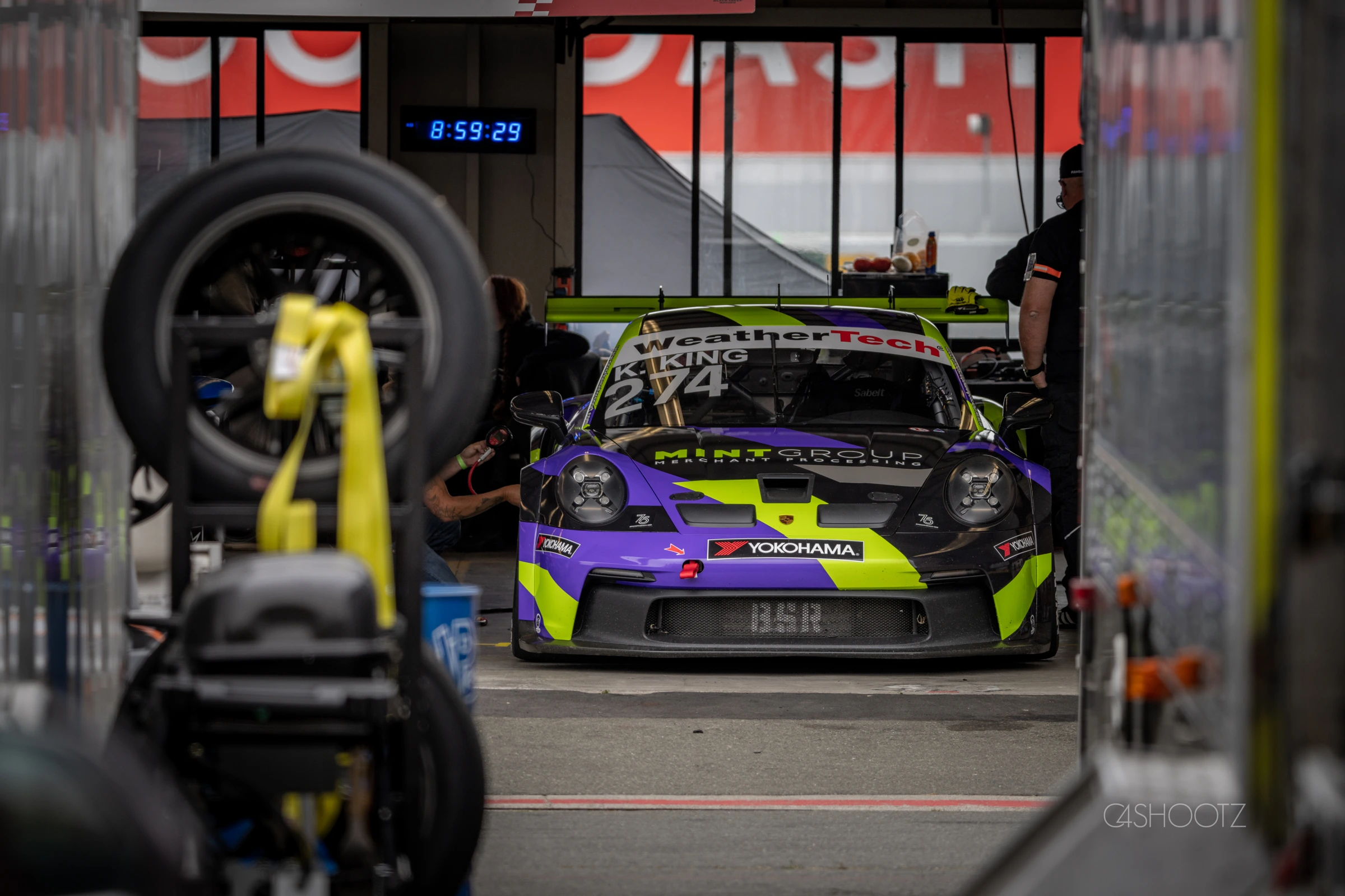 Purple and lime number 274 Porsche being prepared in the garage