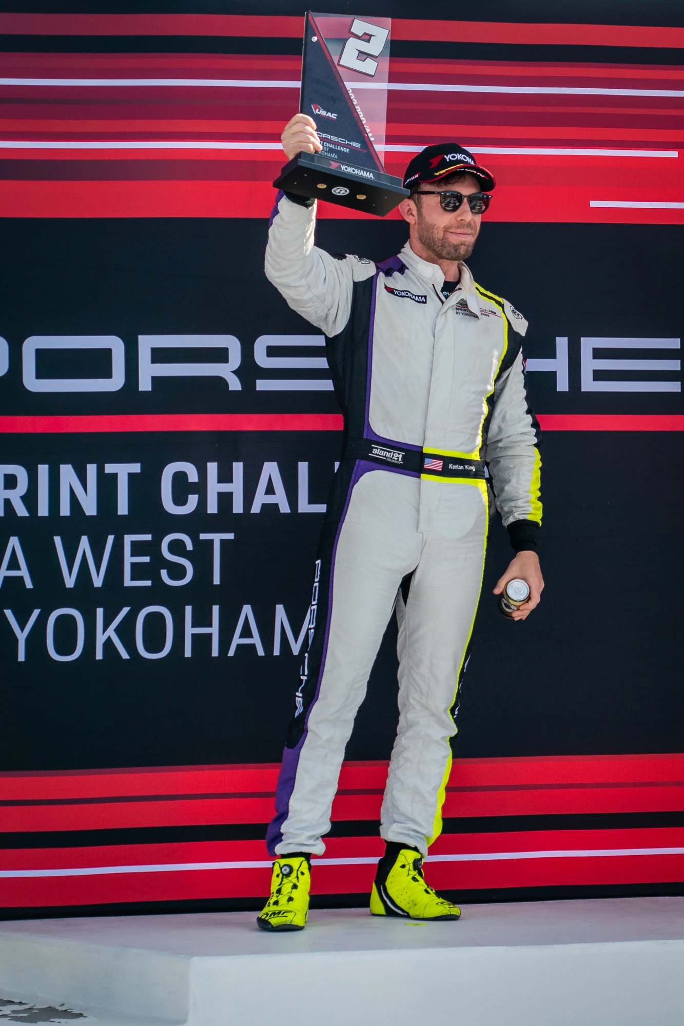 Kenton King holding a second-place trophy on the podium